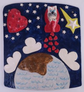 Ceramic painting of cat in rocket ship flying through space